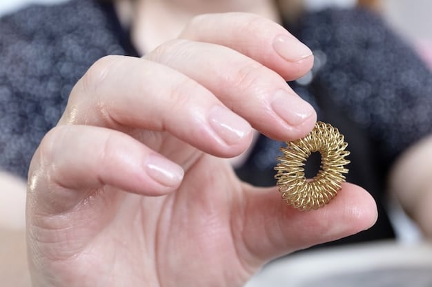 A close-up of a small, strong magnet being held near a gold-colored necklace, demonstrating the magnet test. The background is a simple, light-colored surface.