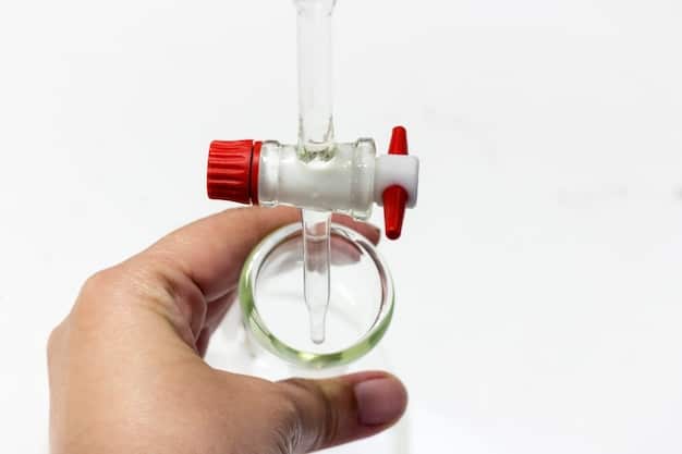 A close-up of a person wearing protective gloves and goggles, carefully applying a drop of liquid from a small bottle onto a piece of jewelry placed on a testing stone. The focus is on the precision and caution of the process.