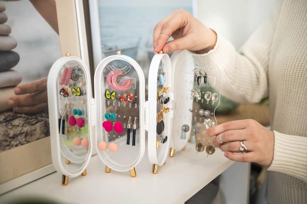 A clear plastic tackle box with various compartments, each holding a different type of costume jewelry like hoop earrings, stud earrings, and rings, showcasing effective organization.