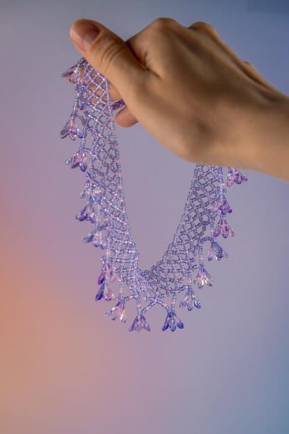 A delicate BioLumin necklace featuring geometric shapes made from a translucent, plant-based material, softly lit to show its intricate details and innovative composition.