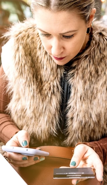 A person holding a credit card and their smartphone, looking up consumer protection laws on the screen, indicating research and awareness of rights.