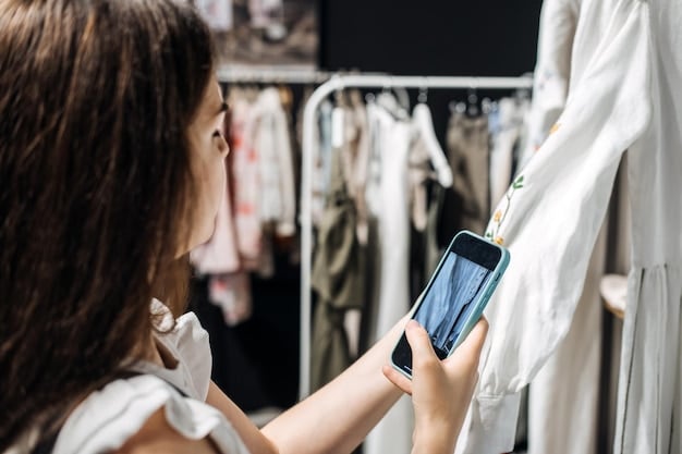 A customer using a mobile phone to scan a barcode in an outlet store for price comparison, with shelves of discounted clothes in the background.