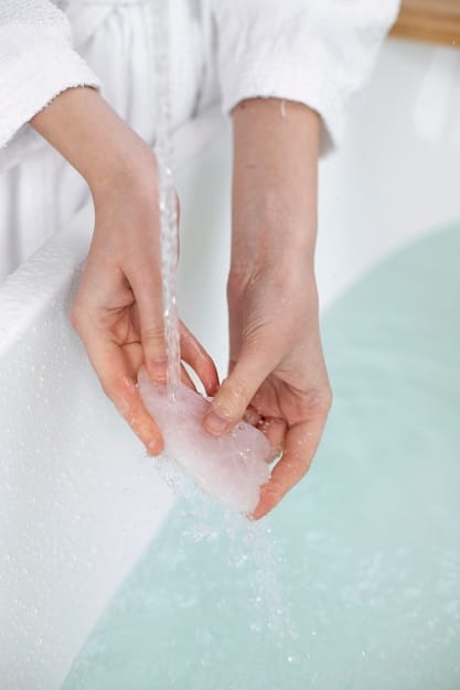 A close-up of hands gently hand-washing a delicate silk scarf in a basin of cool water, with suds visible.