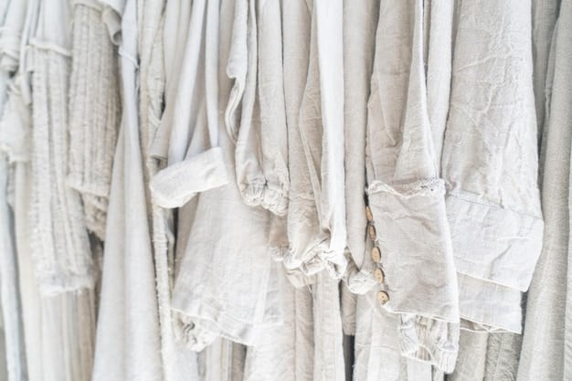 A neatly organized capsule wardrobe rack, featuring light-colored summer clothes like linen pants, cotton shirts, and dresses, demonstrating minimalist organization.