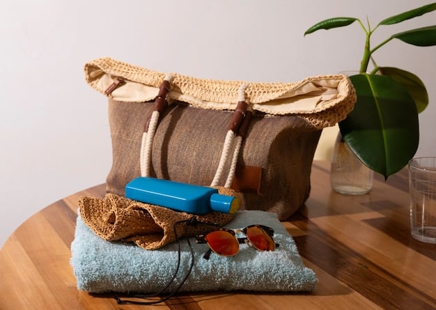 A close-up shot of a chic straw tote bag with leather handles, adorned with a colorful silk scarf, resting on a beach towel with a wide-brimmed hat in the background.