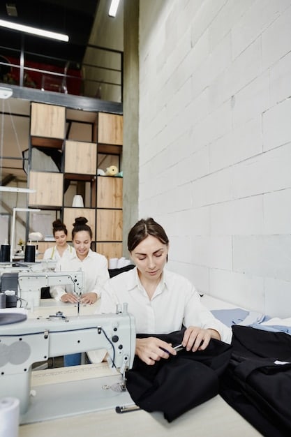 A group of textile workers in a clean, brightly lit, modern factory, carefully inspecting garments. The scene emphasizes ethical production and fair labor, showing a positive and healthy working environment.