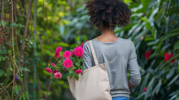 A person holding a large, personalized canvas tote bag filled with fresh produce and flowers, walking away from a bustling farmers market on a sunny morning.