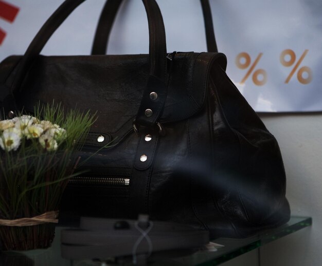 A close-up shot of a designer handbag displayed on a shelf in an elegant outlet store, with price tags clearly showing a significant discount.